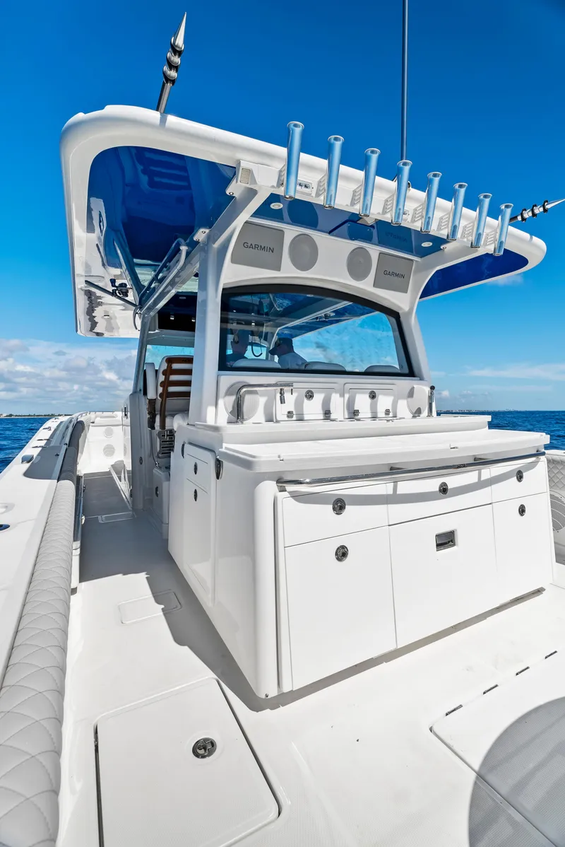 Slide: The Image of 2022 HCB Suenos boat with sleek design and fishing rod holders on open sea. - 12