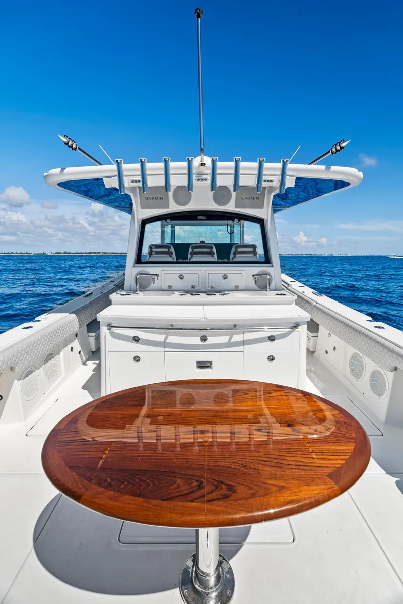 Slide: The Image of 2022 HCB Suenos boat with wooden table, open sea view, clear blue sky. - 15
