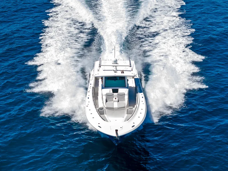 Slide: The Image of 2022 HCB Suenos boat cruising on open blue water, creating a dynamic wake. - 2