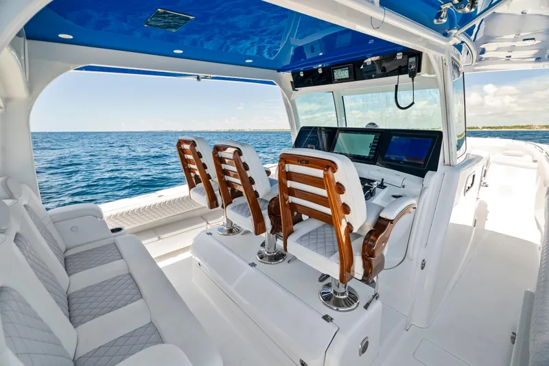 Slide: The Image of 2022 HCB Suenos boat interior with luxurious seating and advanced navigation system on open water. - 22