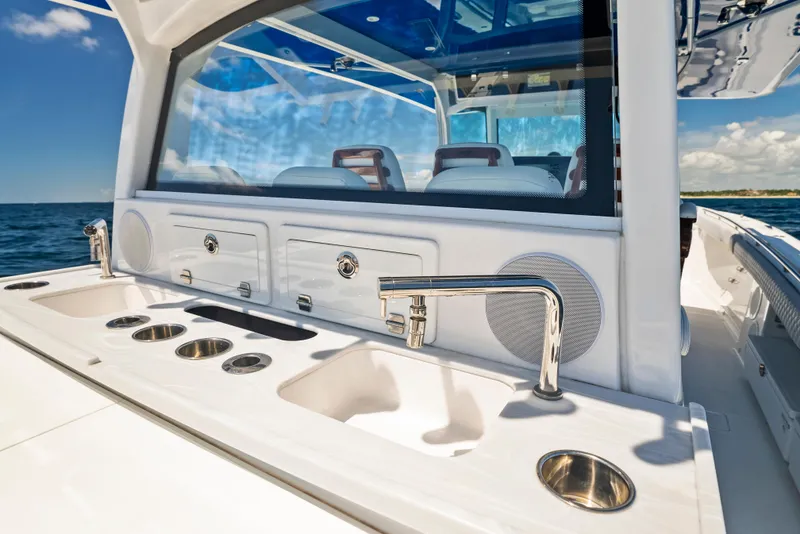 Slide: The Image of 2022 HCB Suenos boat interior with sleek sink and faucet, ocean view in background. - 29