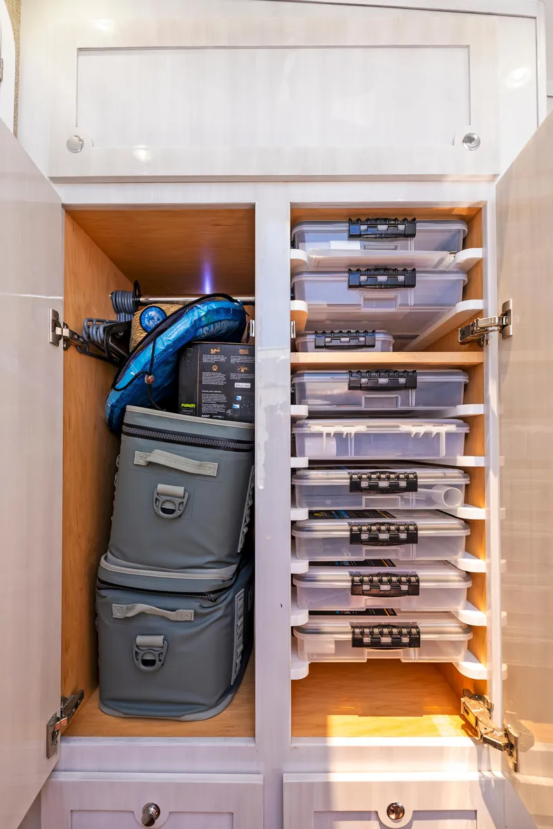 Slide: The Image of Storage cabinet with organized containers and bags on a 2022 HCB Suenos boat. - 39