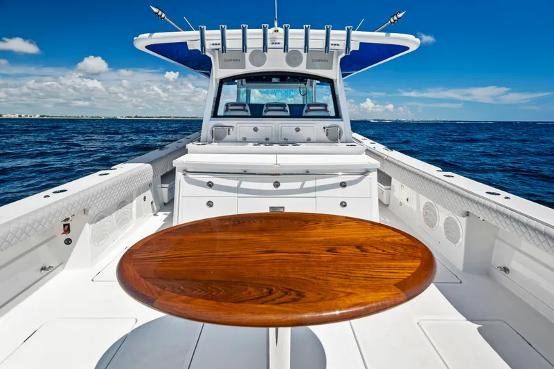 Slide: The Image of 2022 HCB Suenos boat with wooden table, cruising on open sea under clear blue sky. - 46
