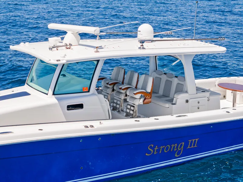 Slide: The Image of 2022 HCB Suenos boat with blue hull, white deck, and seating, cruising on open water. - 1