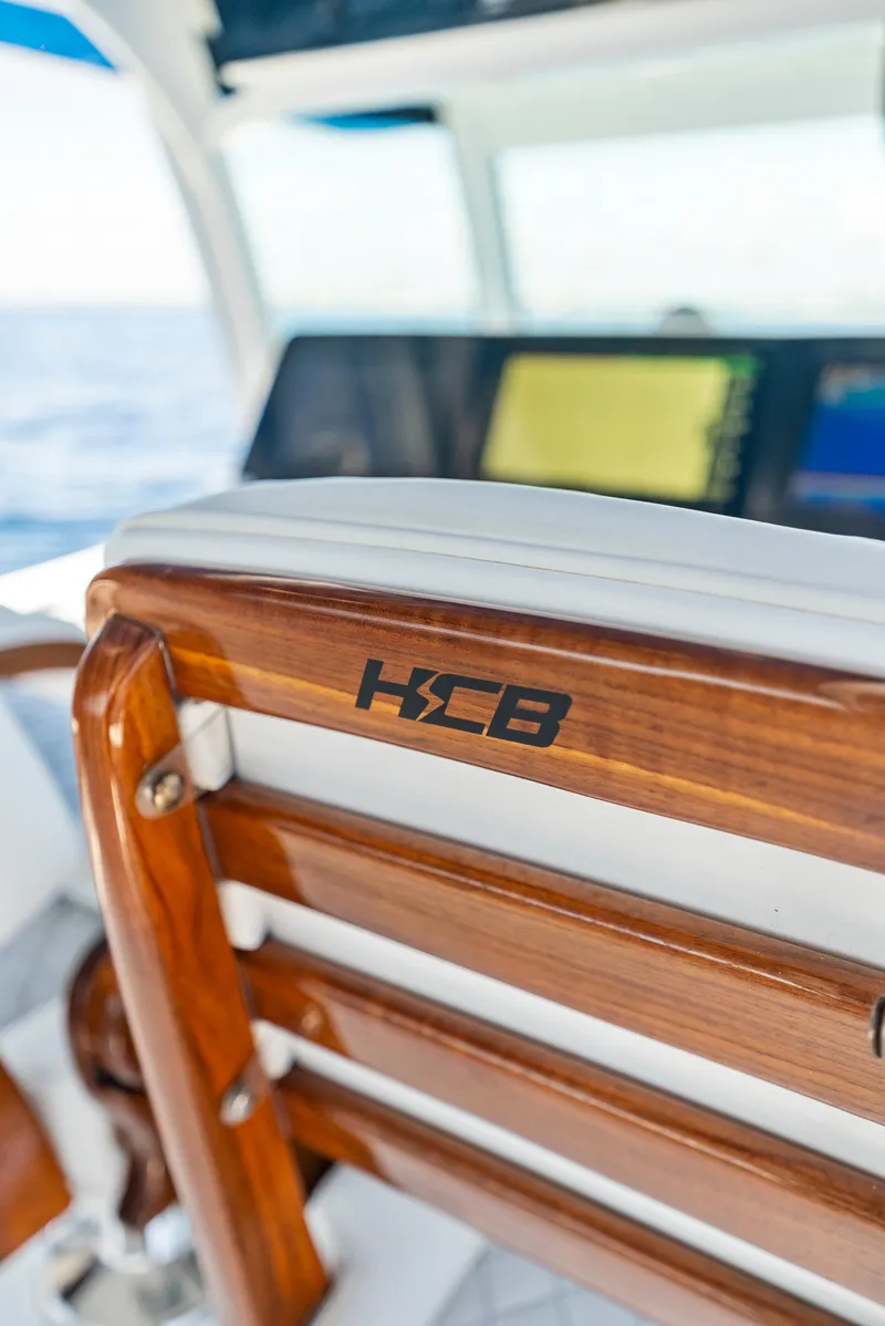Slide: The Image of 2022 HCB Suenos boat interior with wooden seating and branded logo. - 23