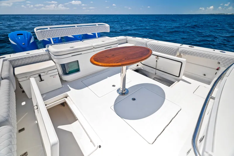 Slide: The Image of 2022 HCB Suenos boat deck with seating and wooden table on open sea. - 33