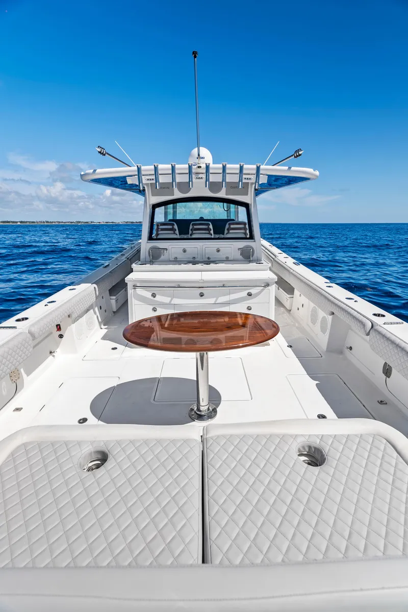 Slide: The Image of 2022 HCB Suenos boat on open sea, featuring luxurious seating and wooden table. - 49