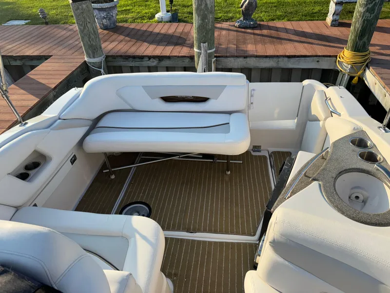 Slide: The Image of 2011 Glastron GS 289 boat interior with white seating and wood deck. - 13