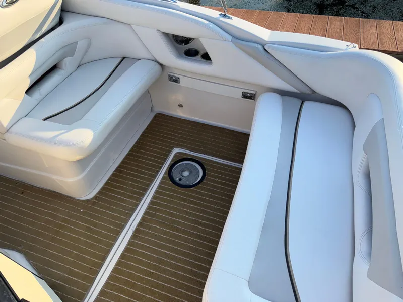 Slide: The Image of 2011 Glastron GS 289 boat interior with white seating and wood-patterned flooring. - 14