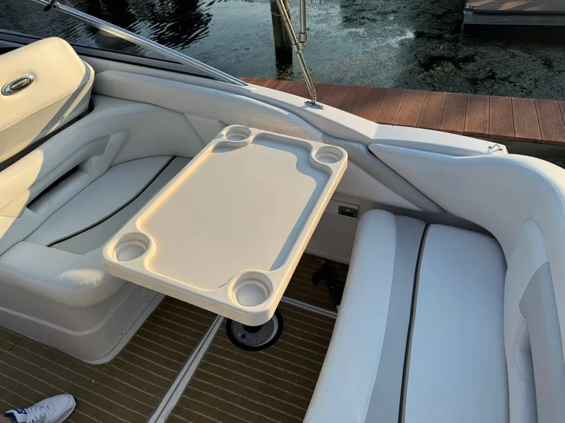 Slide: The Image of 2011 Glastron GS 289 boat interior with seating and table, docked by the water. - 19