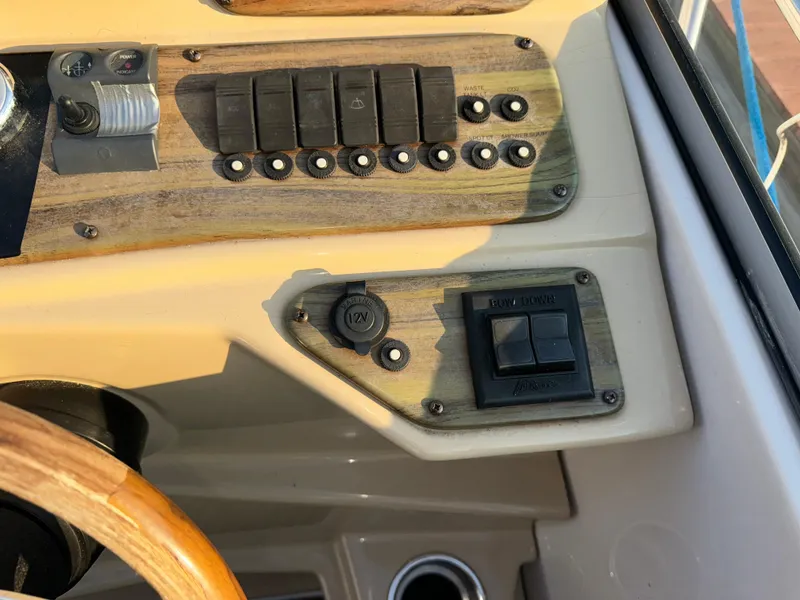 Slide: The Image of Control panel of a 2011 Glastron GS 289 boat with switches and wood accents. - 24