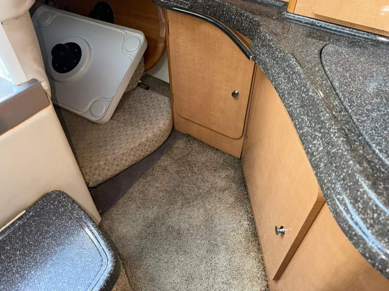 Slide: The Image of Interior of 2011 Glastron GS 289 boat with carpeted flooring and wooden cabinetry. - 45
