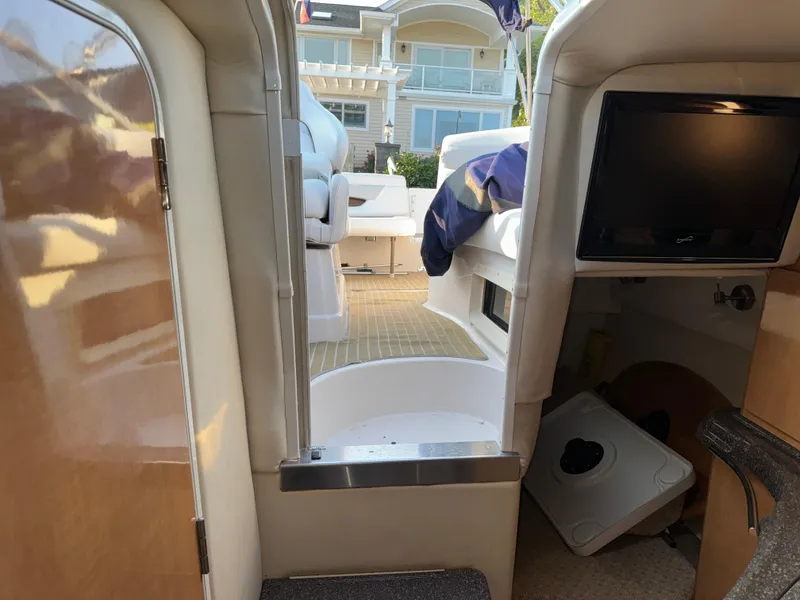 Slide: The Image of Interior view of 2011 Glastron GS 289 boat, featuring seating and a small TV. - 46