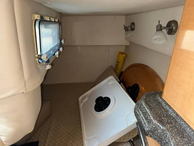 Slide: The Image of 2011 Glastron GS 289 cabin interior with window, table, and lighting fixtures. - 48