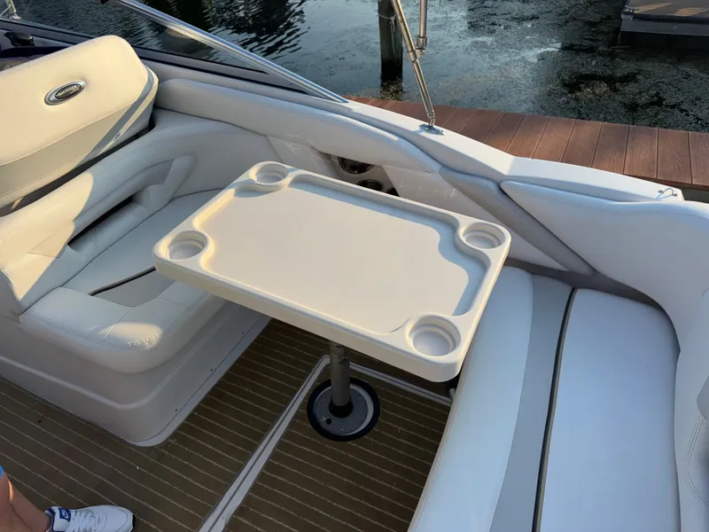 Slide: The Image of 2011 Glastron GS 289 boat interior with seating and table, dockside view. - 18