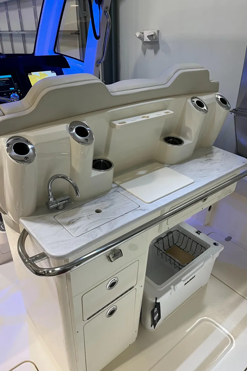 Slide: The Image of 2025 Scout 260 LXF boat interior with sink, storage, and rod holders. - 12