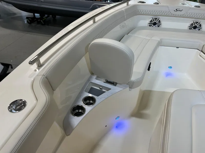 Slide: The Image of 2025 Scout 260 LXF boat interior with white seating, cup holders, and blue LED lights. - 8