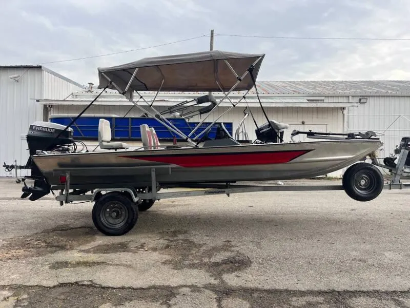 Slide: The Image of 1990 Bass Tracker Pro 17 fishing boat on trailer with canopy and Evinrude motor. - 2