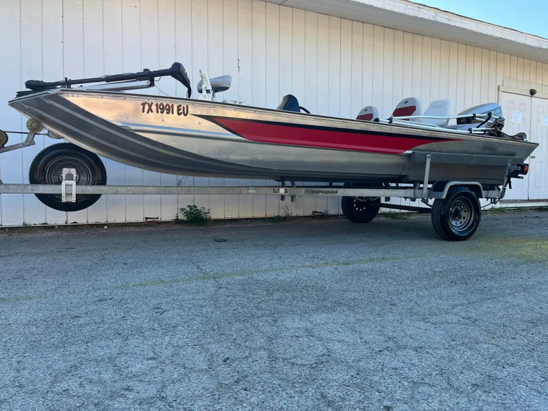 Slide: The Image of 1990 Bass Tracker Pro 17 boat on a trailer, side view. - 27