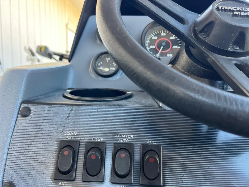 Slide: The Image of 1990 Bass Tracker Pro 17 boat dashboard with steering wheel and control switches. - 44