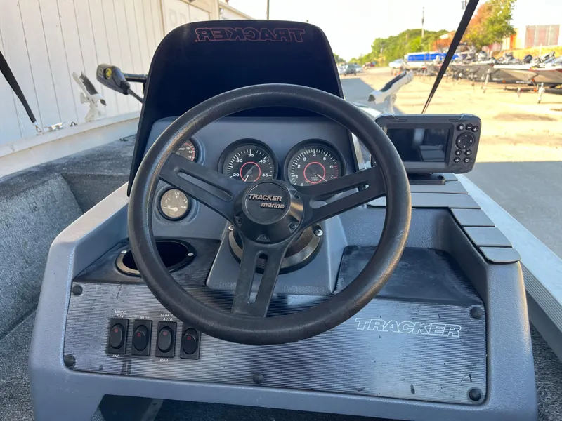Slide: The Image of 1990 Bass Tracker Pro 17 boat dashboard with steering wheel and gauges. - 45