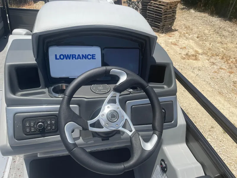 Slide: The Image of 2024 Regency 230 DL3 boat dashboard with Lowrance display and steering wheel. - 10