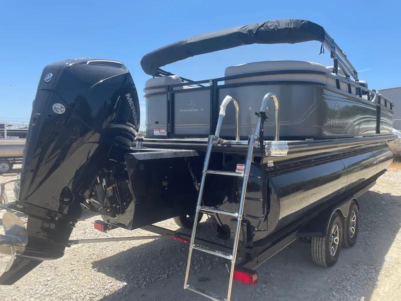 Slide: The Image of 2024 Regency 230 DL3 pontoon boat with Mercury outboard motor and ladder, parked on gravel. - 3