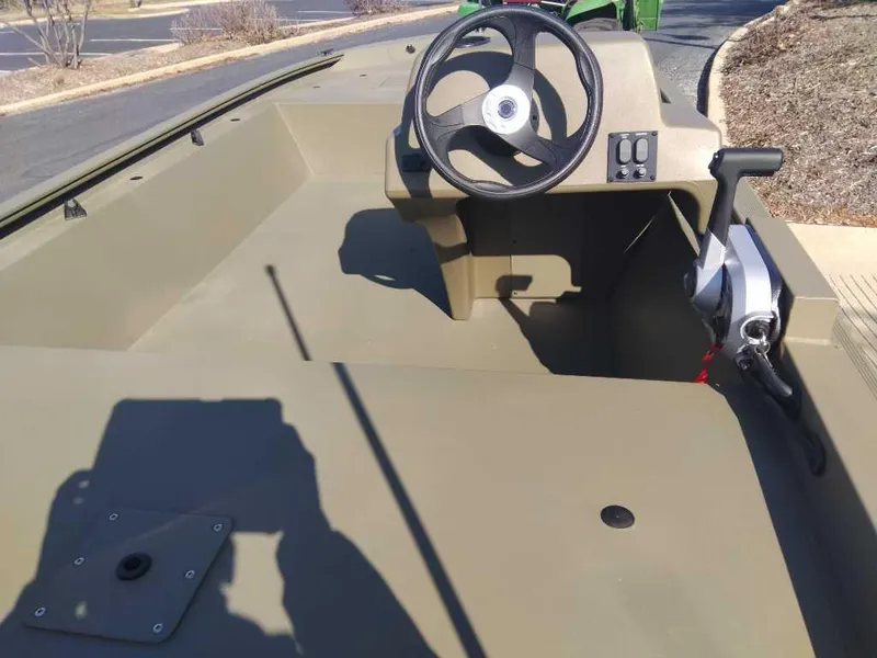 Slide: The Image of 2024 Tracker Grizzly 1648 SC boat interior with steering wheel and control panel. - 2