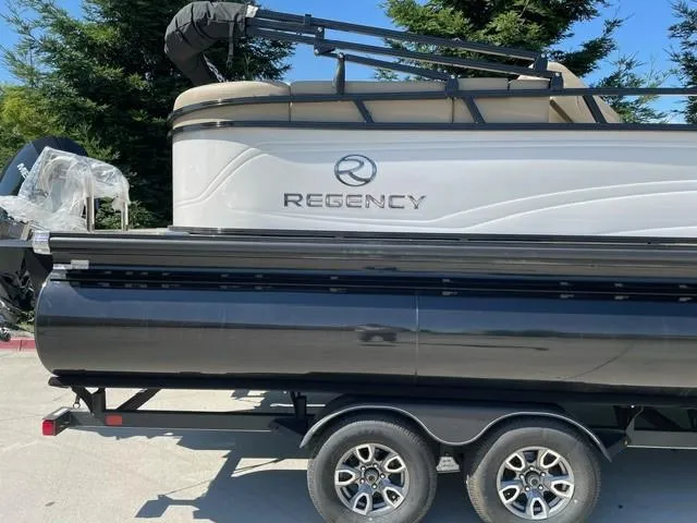 Slide: The Image of 2024 Regency 230 DL3 pontoon boat on a trailer. - 1