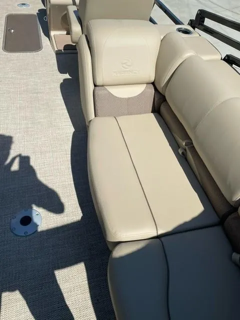 Slide: The Image of 2024 Regency 230 DL3 boat interior with beige leather seating and carpeted flooring. - 14