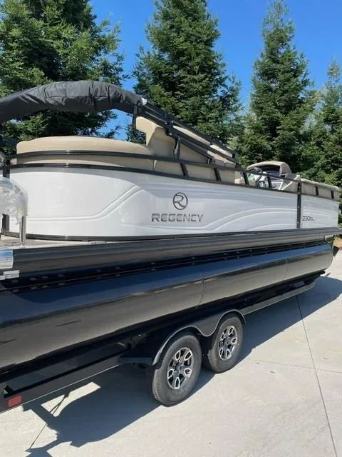 Slide: The Image of 2024 Regency 230 DL3 pontoon boat on a trailer, side view. - 9