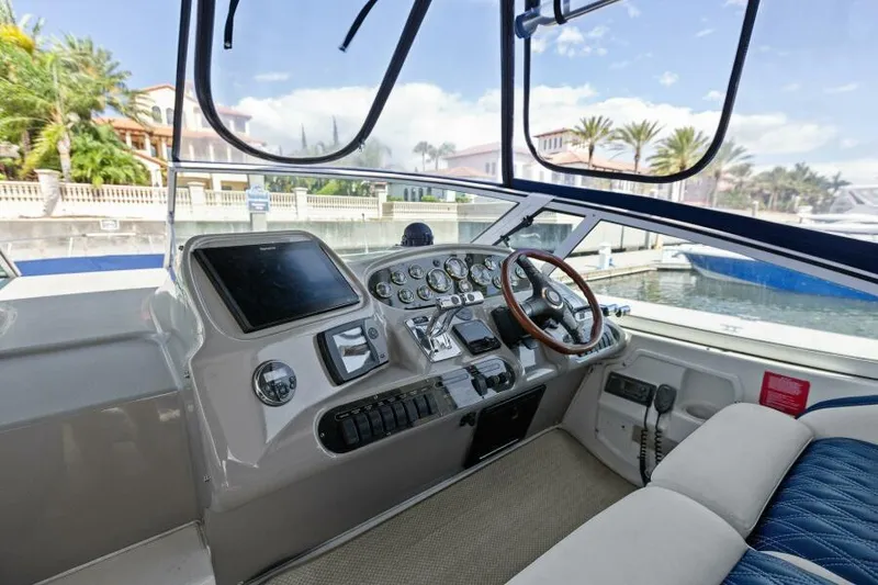 Slide: The Image of 2002 Cruisers Yachts 3672 Express helm with modern controls and waterfront view. - 17