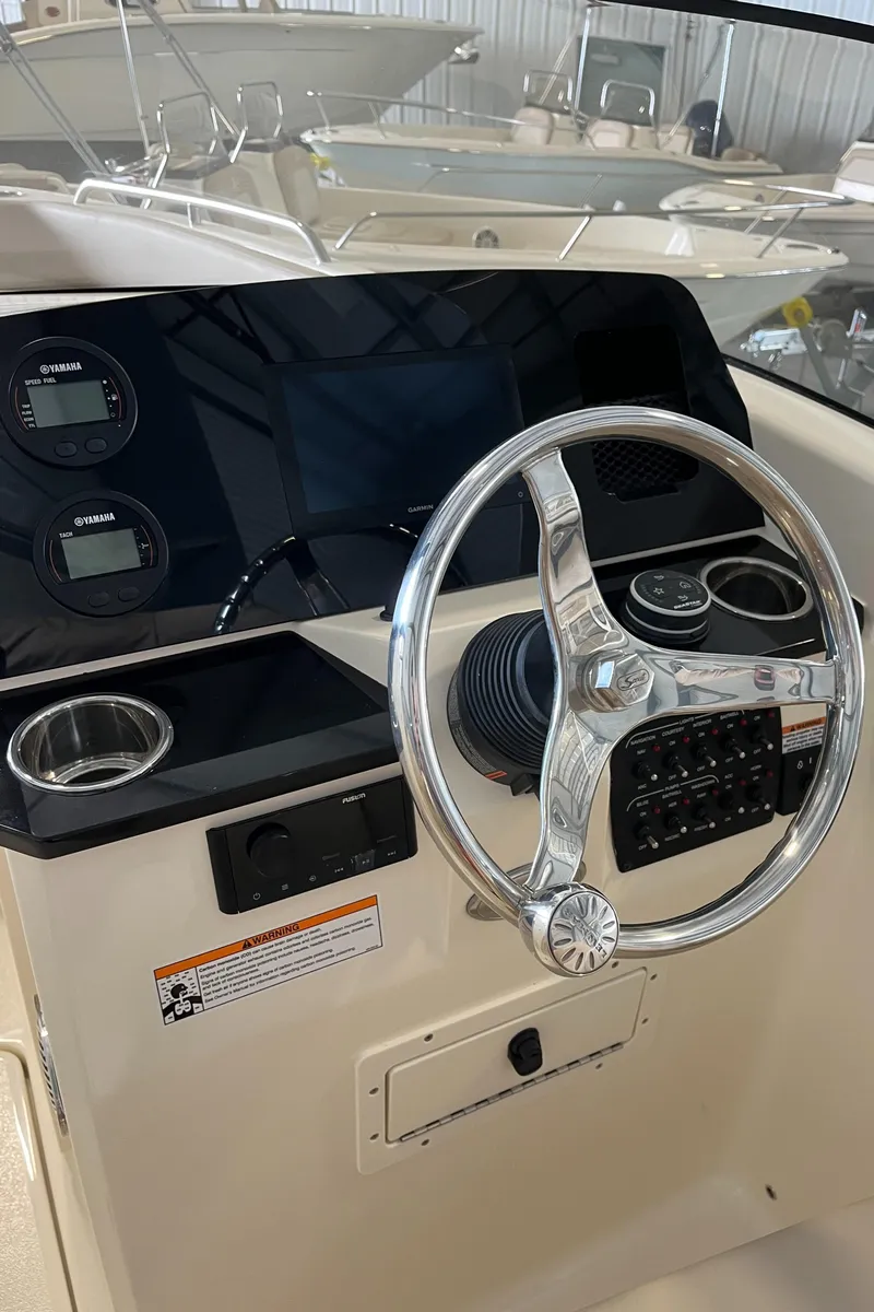 Slide: The Image of 2024 Scout 215 Dorado boat dashboard with steering wheel and control panel. - 12