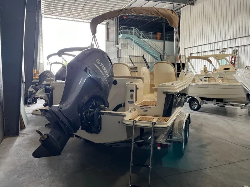 Slide: The Image of 2024 Scout 215 Dorado boat with Yamaha outboard motor in a storage facility. - 2