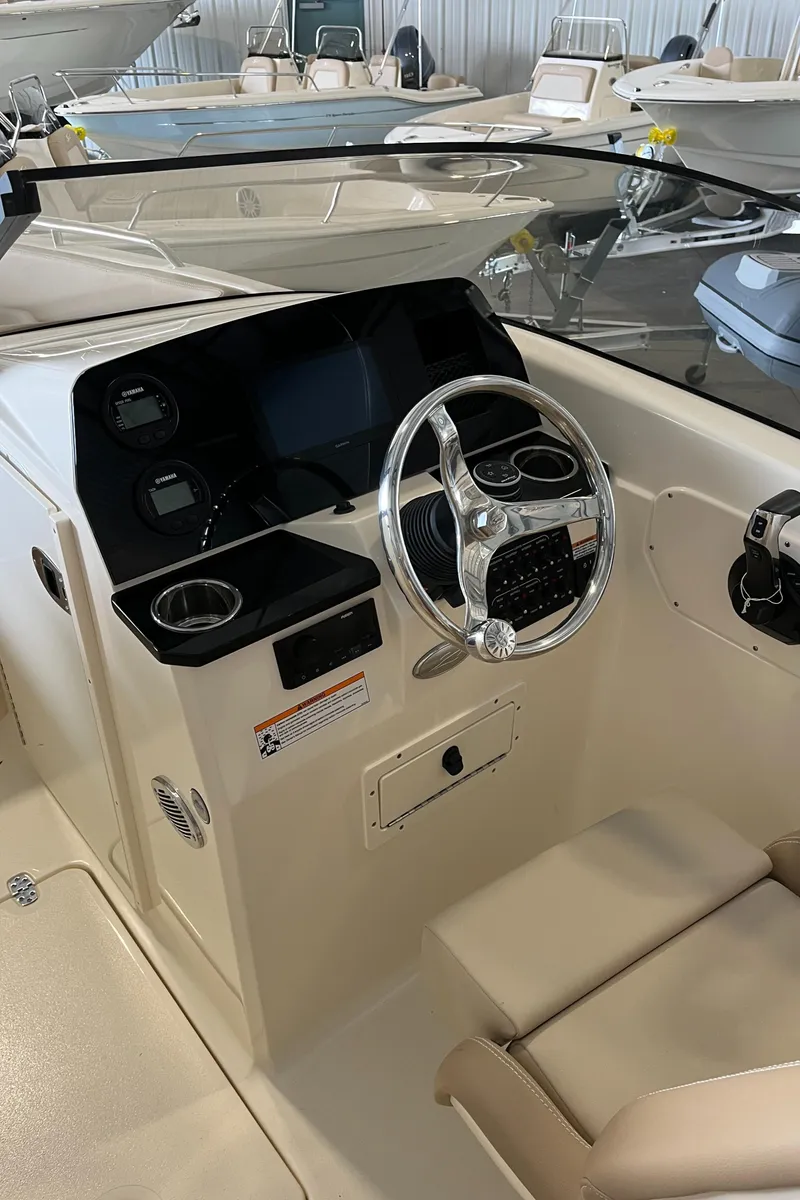 Slide: The Image of 2024 Scout 215 Dorado boat dashboard with steering wheel and controls. - 9
