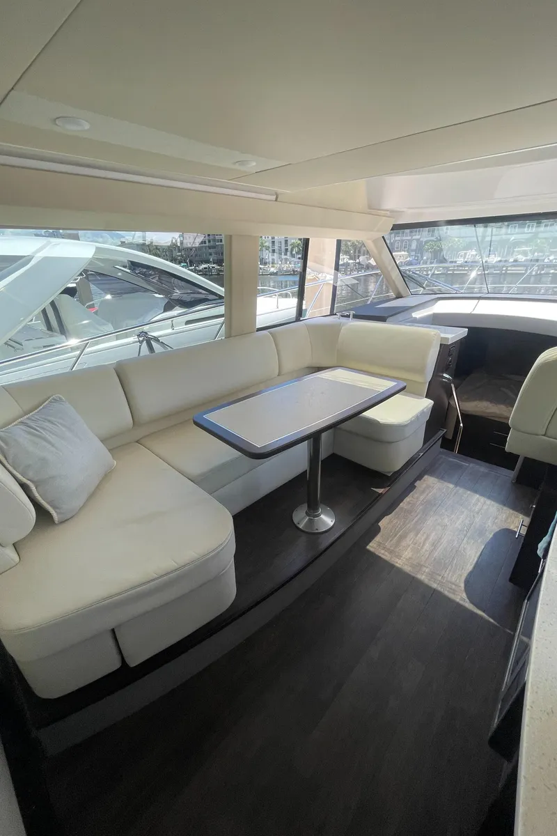 Slide: The Image of 2019 Regal 42 Grande Coupe yacht interior with plush seating and dining table. - 10