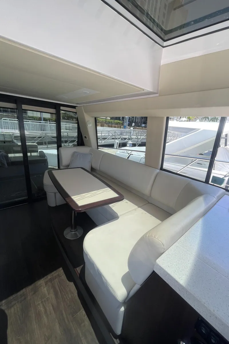 Slide: The Image of Interior of 2019 Regal 42 Grande Coupe yacht with white seating and dining table. - 12