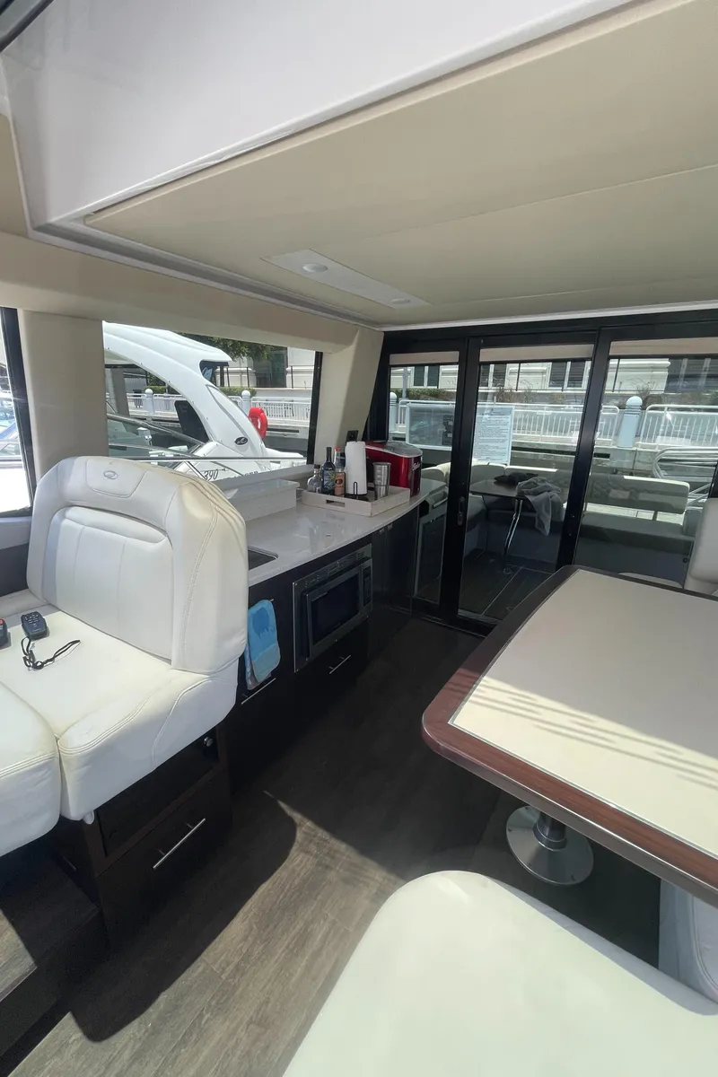 Slide: The Image of Interior of 2019 Regal 42 Grande Coupe yacht with modern seating and kitchen area. - 13