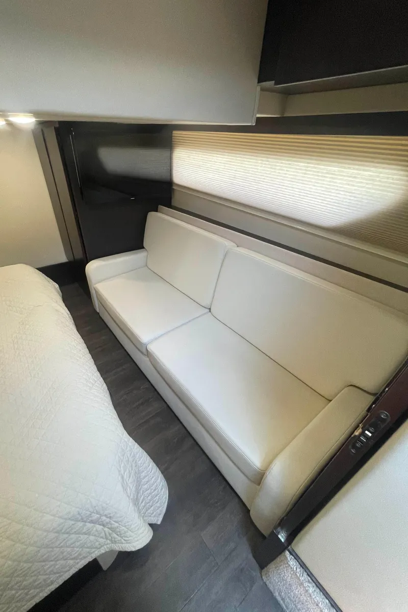 Slide: The Image of Interior of 2019 Regal 42 Grande Coupe with white sofa and bed. - 25