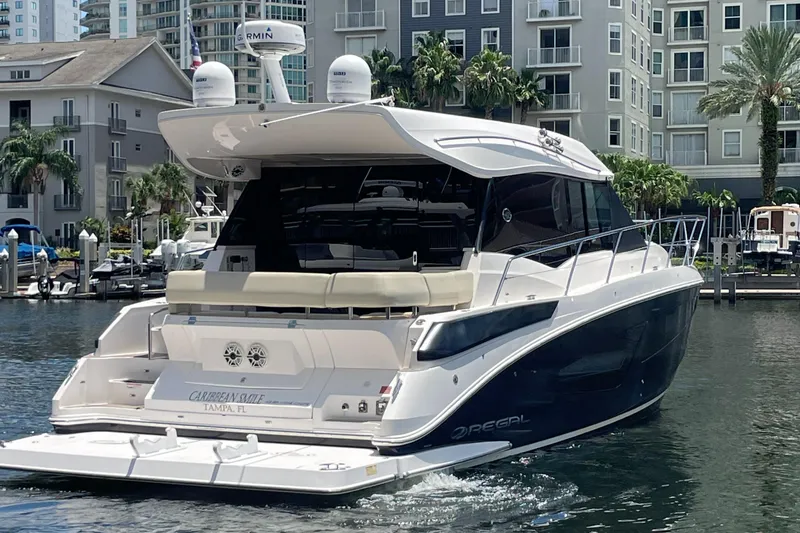 Slide: The Image of 2019 Regal 42 Grande Coupe yacht docked in a marina with waterfront buildings. - 3