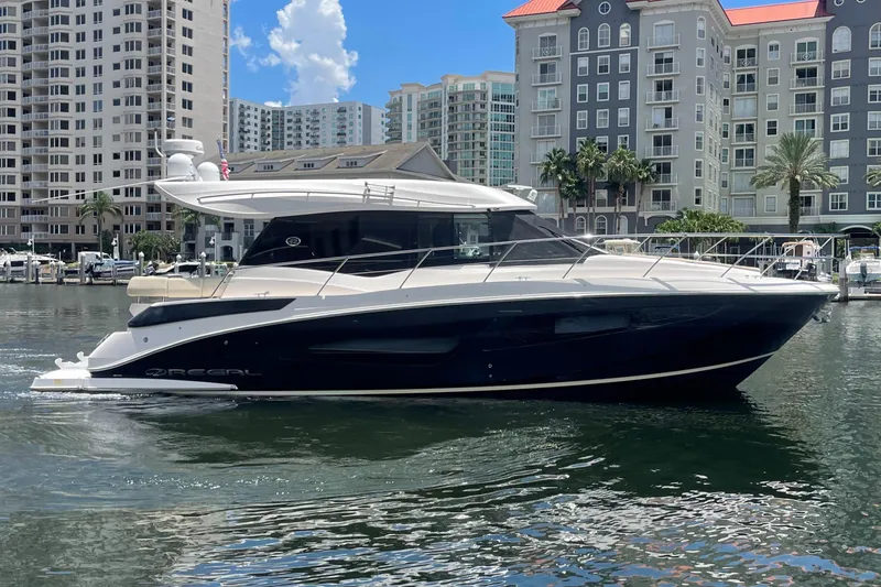 Slide: The Image of 2019 Regal 42 Grande Coupe yacht docked in a marina with cityscape background. - 34