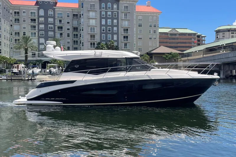 Slide: The Image of 2019 Regal 42 Grande Coupe yacht docked in a marina with waterfront buildings. - 36