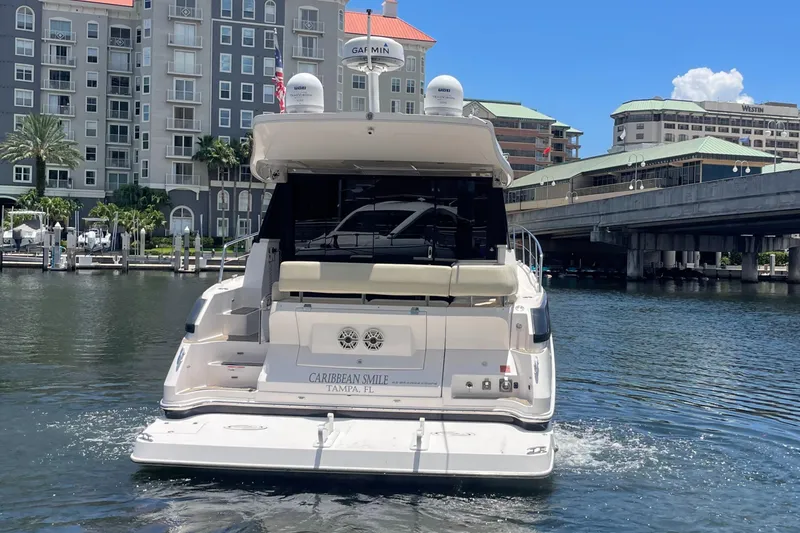 Slide: The Image of 2019 Regal 42 Grande Coupe yacht docked in a marina with waterfront buildings. - 37