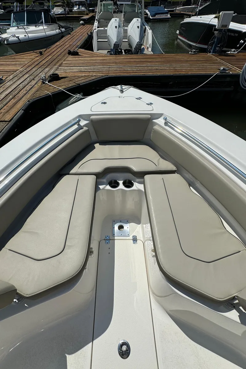 Slide: The Image of 2023 Key West 239 FS boat interior with cushioned seating at the dock. - 15