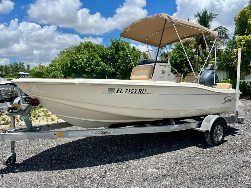 Slide: The Image of 2019 Scout Sportfish 175 boat on a trailer under a sunny sky. - 2