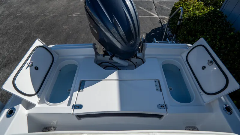 Slide: The Image of 2025 Tidewater 2210 Carolina Bay boat with open storage compartments and outboard motor. - 10