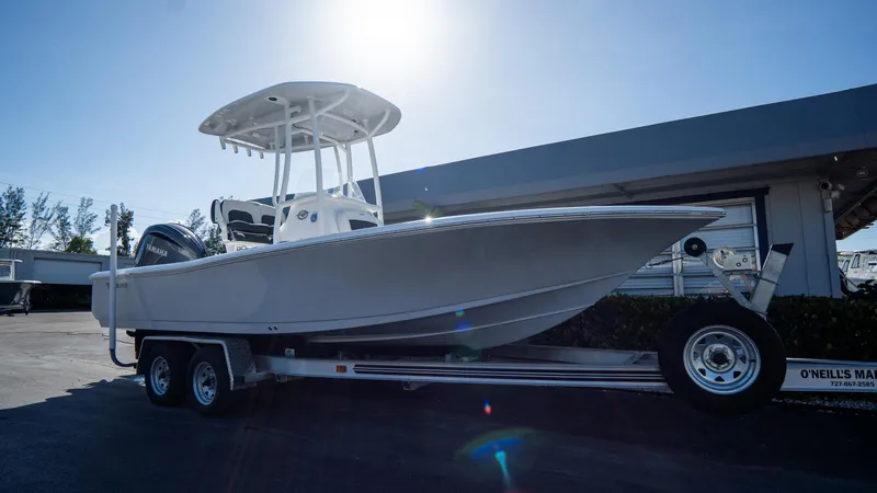 Slide: The Image of 2025 Tidewater 2210 Carolina Bay boat on a trailer in a sunny marina. - 2