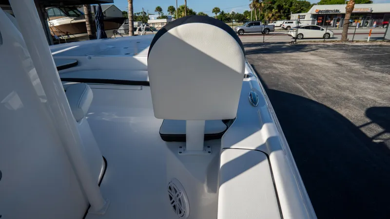 Slide: The Image of 2025 Tidewater 2210 Carolina Bay boat interior with white seating and speaker. - 25