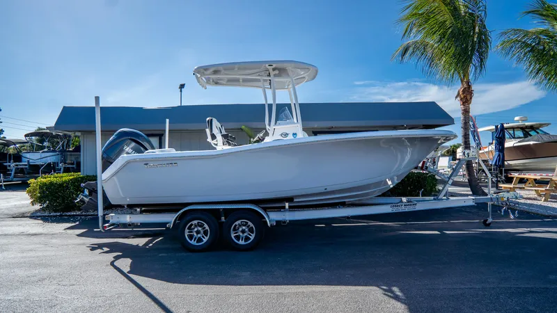 The Image of 2025 Tidewater 220 LXF boat on trailer, parked outdoors under clear blue sky. - 0