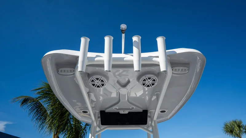 Slide: The Image of 2025 Tidewater 220 LXF boat with rod holders and speakers against a clear blue sky. - 13